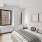 Bedroom with queen bed, dresser, mirror, and lots of natural light.
